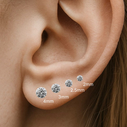 Close-up of an ear with diamond piercings labeled by size.
